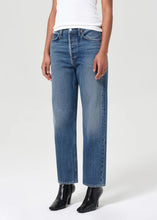 Load image into Gallery viewer, Agolde's best-selling 90's Jean in medium vintage indigo with subtle fading, marbling, and whiskering details. This decade inspired mid-rise is designed to sit relaxed at the waist with an easy fit through the hips into a classic, loose straight leg. Style back to anything and everything. Available at aprilmae - a womenswear boutique located in Chiswick west London specialising in contemporary, everyday clothing for women. Visit our shop on Devonshire Road W4 for the latest arrivals.