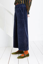 Load image into Gallery viewer, Bijou by Bonte is a loose + relaxed fitting, 3/4 length, wide-leg pull-on trouser, with an elasticated back, in a garment washed organic cotton bay-cord, in a versatile navy blue. Side seam pockets with stitch-through detail. Twin-needle stitching throughout. Available at aprilmae - a womenswear boutique located in Chiswick west London specialising in contemporary, everyday clothing for women.  Visit our shop on Devonshire Road W4 for the latest arrivals from brands including Rains, Rails and Bellerose.
