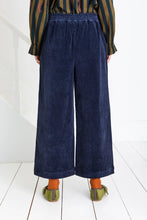 Load image into Gallery viewer, Bijou by Bonte is a loose + relaxed fitting, 3/4 length, wide-leg pull-on trouser, with an elasticated back, in a garment washed organic cotton bay-cord, in a versatile navy blue. Side seam pockets with stitch-through detail. Twin-needle stitching throughout. Available at aprilmae - a womenswear boutique located in Chiswick west London specialising in contemporary, everyday clothing for women.  Visit our shop on Devonshire Road W4 for the latest arrivals from brands including Rains, Rails and Bellerose.
