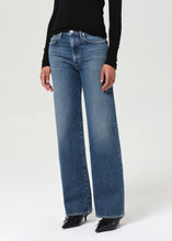 Load image into Gallery viewer, The Harper from AGolde is the perfectly broken-in straight leg. This mid-rise pair comes in a medium-to-dark indigo wash with subtle marbling and fade, offering a lived-in feel from the first wear. Cut from a soft, comfort-stretch regenerative denim, it’s relaxed through the leg with a classic straight fit. Available at aprilmae - a womenswear boutique located in Chiswick west London specialising in contemporary, everyday clothing for women.  Visit our shop on Devonshire Road W4.
