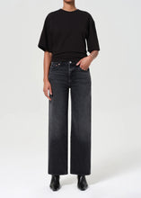 Load image into Gallery viewer, The Harper from AGolde is the perfectly broken-in straight leg. This mid-rise pair comes in a washed-out black with subtle fading and whiskering, offering a lived-in feel from the first wear. Cut from a soft, comfort-stretch regenerative denim, it’s relaxed through the leg with a classic straight fit. Available at aprilmae - a womenswear boutique located in Chiswick west London specialising in contemporary, everyday clothing for women.  Visit our shop on Devonshire Road W4.
