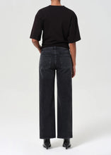 Load image into Gallery viewer, The Harper from AGolde is the perfectly broken-in straight leg. This mid-rise pair comes in a washed-out black with subtle fading and whiskering, offering a lived-in feel from the first wear. Cut from a soft, comfort-stretch regenerative denim, it’s relaxed through the leg with a classic straight fit. Available at aprilmae - a womenswear boutique located in Chiswick west London specialising in contemporary, everyday clothing for women.  Visit our shop on Devonshire Road W4.
