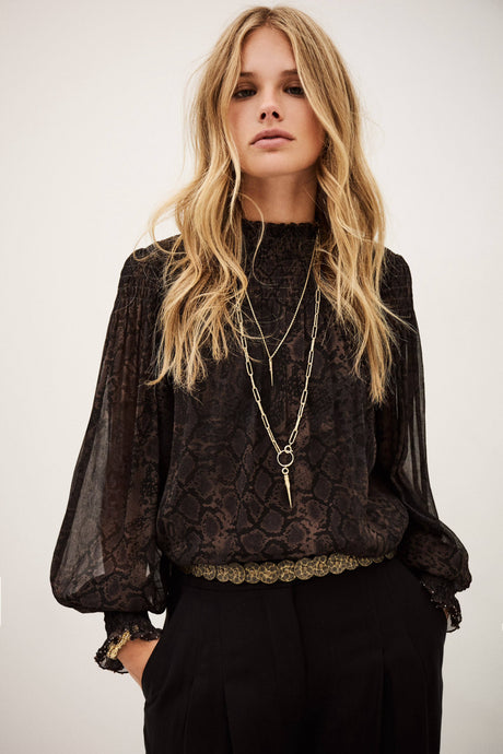 Woman wearing a black lace top with sheer sleeves against a white background
ba&sh shamy blouse snake print chiffon top aprilmae chiswick London